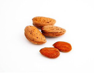 A pile of wild peeled almond nuts and kernels, closeup, isolated on white background.