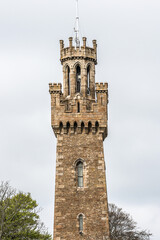 Obraz premium Victoria Tower and Candie Road Cemetery. Victoria Tower - famous monument in Saint Peter Port, Guernsey, erected in honor of visit by Queen Victoria and Prince Albert to Island in 1846.
