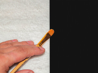 Brush for painting in hand on a black and white background