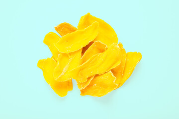 A heap of mango slices on a blue background, top view