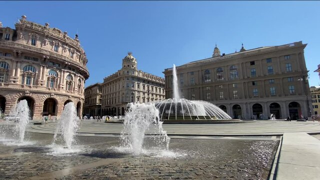 Genova, Italy, fountain in De Ferrari square, the heart of the city with the central fountain and the Liberty architecture of the Stock Exchange palace