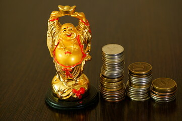 Buddha figure with coins on a dark background.