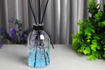 The luxury scented aroma room fresherner reed diffser glass bottle with black fiber sticks in the nice bed room