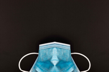 blue medical or Surgical face Mask. Virus Protection. Black background. Space for entering text 