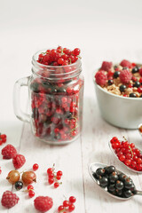 Colorful fresh berries on white background. Oatmeal with berries currants, raspberries, gooseberries. Vitamins, Diet. Copy space. Healthly food, detox. Cozy good morning! Summer Healthy breakfast