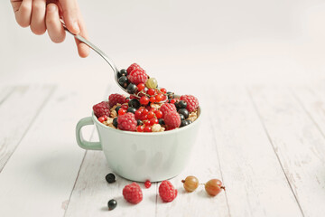 Colorful fresh berries on white background. Oatmeal with berries currants, raspberries, gooseberries. Vitamins, Diet. Copy space. Healthly food, detox. Cozy good morning! Summer Healthy breakfast