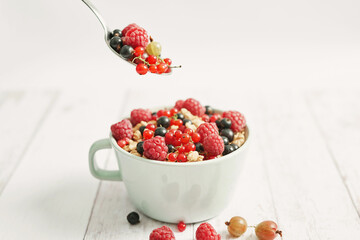 Colorful fresh berries on white background. Oatmeal with berries currants, raspberries, gooseberries. Vitamins, Diet. Copy space. Healthly food, detox. Cozy good morning! Summer Healthy breakfast
