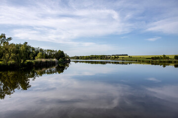 beautiful lake with small waves on the background of sky with clouds. A typical pond in the countryside