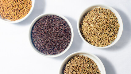 Best of Ceylon Spices; Cumin seeds, Caraway seeds, Mustard seeds, Fenugreek seeds in bowls. Isolated on white background