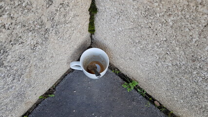 Tasse de café vide sur un trottoir.