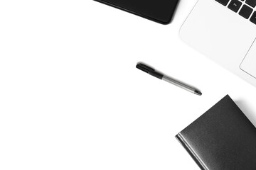 Black pen, smartphone, white laptop on a white background. The concept of business, training, workplace. Minimalistic monochrome flat lay.
