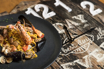 Lunch time - Spaghetti with seafood on wooden background with lunch time