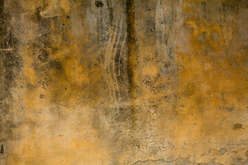 Yellow dirty stucco or plastered wall with cracks. Close up shot. Grunge abstract texture or background. Retro concept.