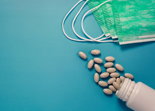 3 ply medical face mask and vitamin C tablets protection from virus, flu, disease isolated on blue background