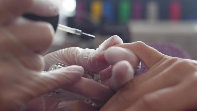 	
Manicurist doing manicure client painting nails with nail polish	
