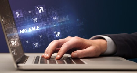 Businessman working on laptop with BIG SALE inscription, online shopping concept