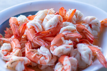 Peeled shrimps in a bowl isolated on white background. Top view