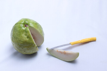 small knife and fresh white guava pieces with insulated white background