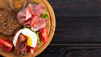 ham and egg bacon sandwich on dark wooden background with copy space. Top view. Flat lay