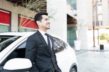 Young Male Executive Standing By Car