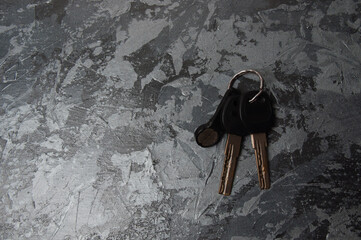 Keys to the house or apartment on a gray concrete background with copy space, view from the top of the flat lay. Concept of buying a secondary in Europe housing