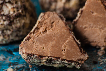 Delicious chocolate candies in waffle crumbs cut in half closeup macro, side view