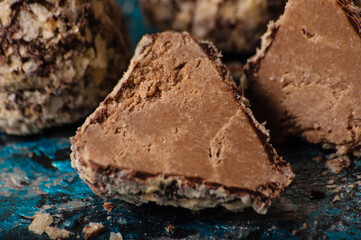 Delicious chocolate candies in waffle crumbs cut in half closeup macro, side view