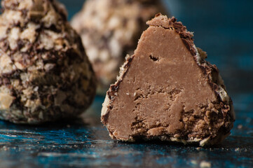Delicious chocolate candies in waffle crumbs cut in half closeup macro, side view