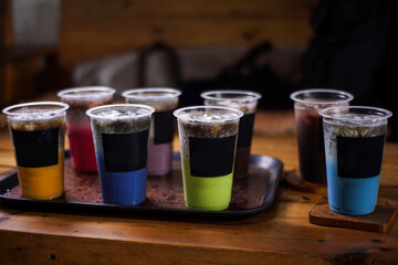 variant of cold drinks with fruit flavor. fresh cafe menu with dark background. colorful ice mockups with plastic cups. grape, chocolate, strawberry, mango, grass jelly,  blueberries, guava