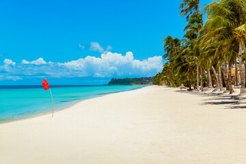 Beautiful landscape of tropical beach on Boracay island, Philippines under lockdoun. Coconut palm trees, sea, sailboat and white sand. Nature view. Summer vacation concept.