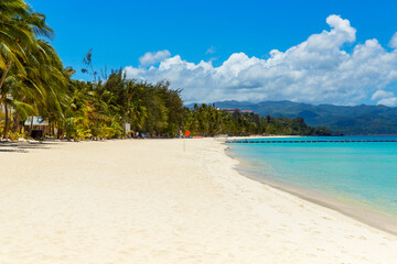 Beautiful landscape of tropical beach on Boracay island, Philippines under lockdoun. Coconut palm trees, sea, sailboat and white sand. Nature view. Summer vacation concept.