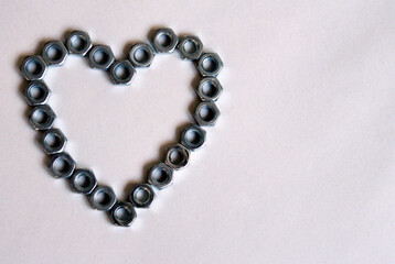 Heart made of metal nuts on a white background