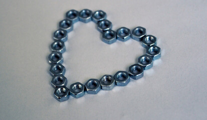 Heart made of metal nuts on a white background