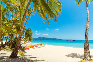 Beautiful landscape of tropical beach on Boracay island, Philippines. Coconut palm trees, sea, sailboat and white sand. Nature view. Summer vacation concept.