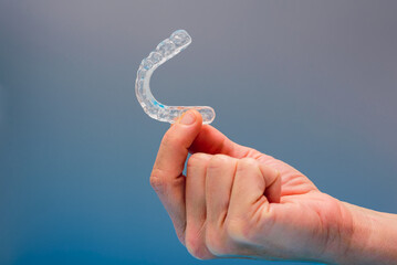 Dental aligner used by dental doctors isolated on blue background.