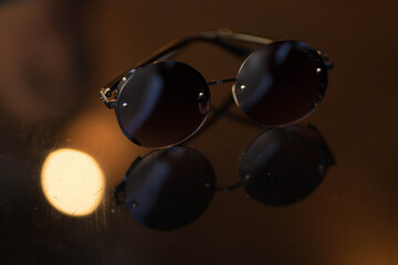 sunglasses with round glasses lie on the table