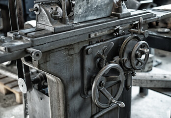 Vintage old factory metal lathe with round wheels