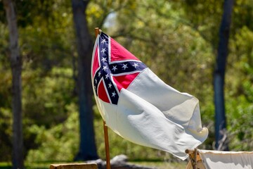 The confederate flag flying over a campsite at a American Civil war reenactment 