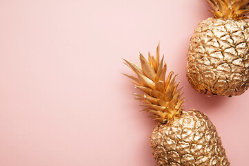 Gold tropical pineapple on a pastel pink background. Flat lay summer background