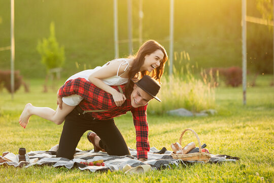Laughting, having fun. Caucasian young couple enjoying weekend together in the park on summer day. Look lovely, happy, cheerful. Concept of love, relationship, wellness, lifestyle. Sincere emotions.