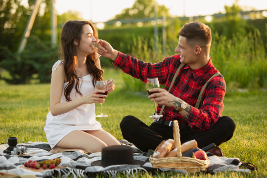 Laughting, having fun. Caucasian young couple enjoying weekend together in the park on summer day. Look lovely, happy, cheerful. Concept of love, relationship, wellness, lifestyle. Sincere emotions.