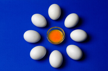 yolk in a spoon on a background of white eggs