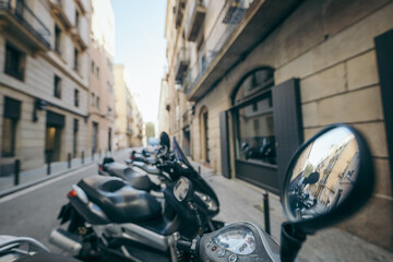 A row of parked motorcycles sitting on the side of a building