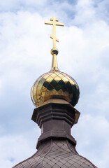 Fototapeta na wymiar bottom view golden domes of christian church with crosses on blue sky background