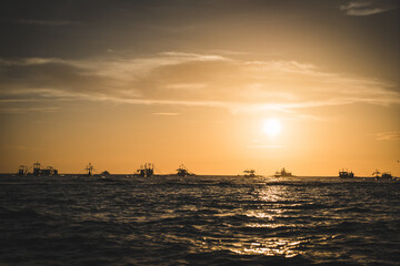 Naklejka na ściany i meble Boats sunset over the sea