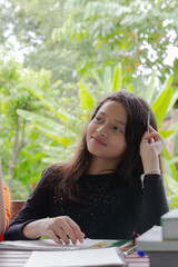 Cute girl doing her homework in the garden at home