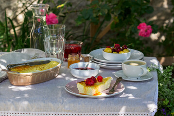 Breakfast in the garden from casseroles, berries, sauces and drinks. Rustic style.