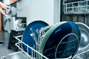 diswasher closeup with woman organizing kitchen objects