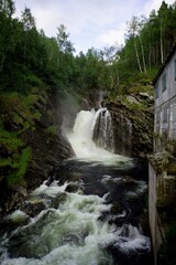 Fototapeta na wymiar Beautiful waterfall by a mill surrounded by Norwegian nature