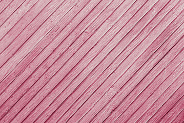 pink abstract background of diagonally arranged old wooden planks with cracked paint texture